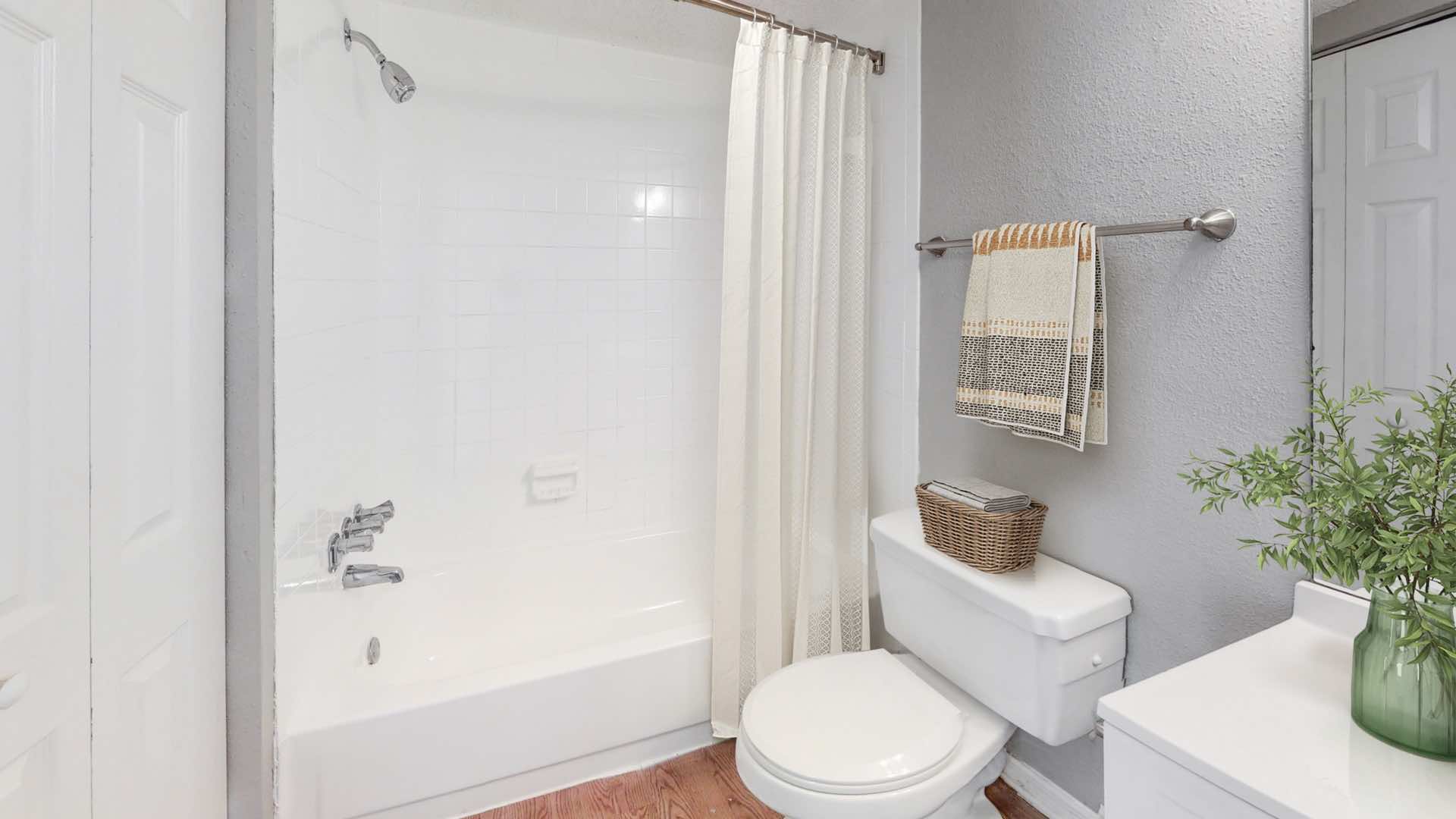 bathroom with curved shower rod and wood-style flooring
