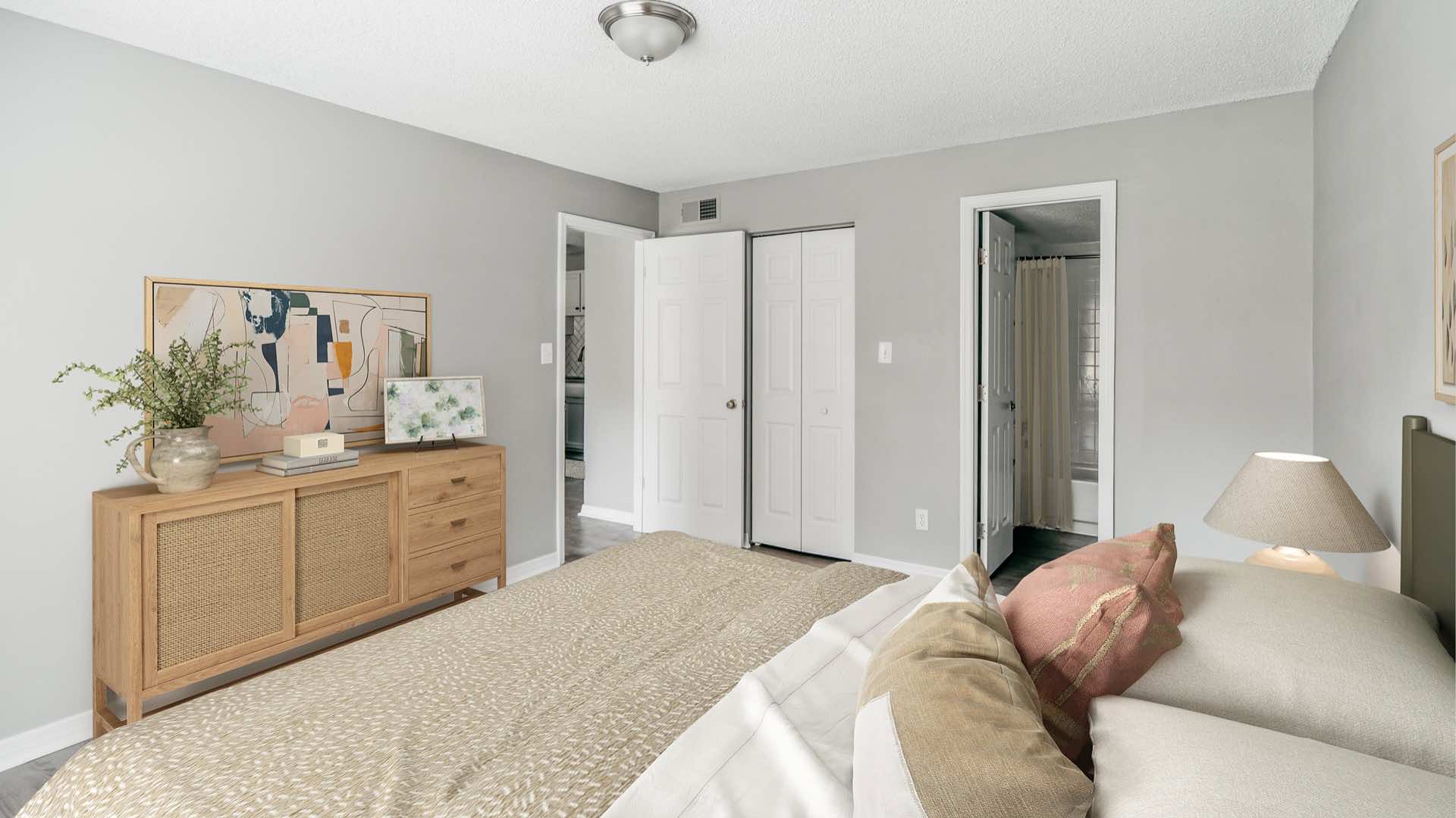 bedroom with bed, brushed nickel lighting showing view of bathroom and doors to living room