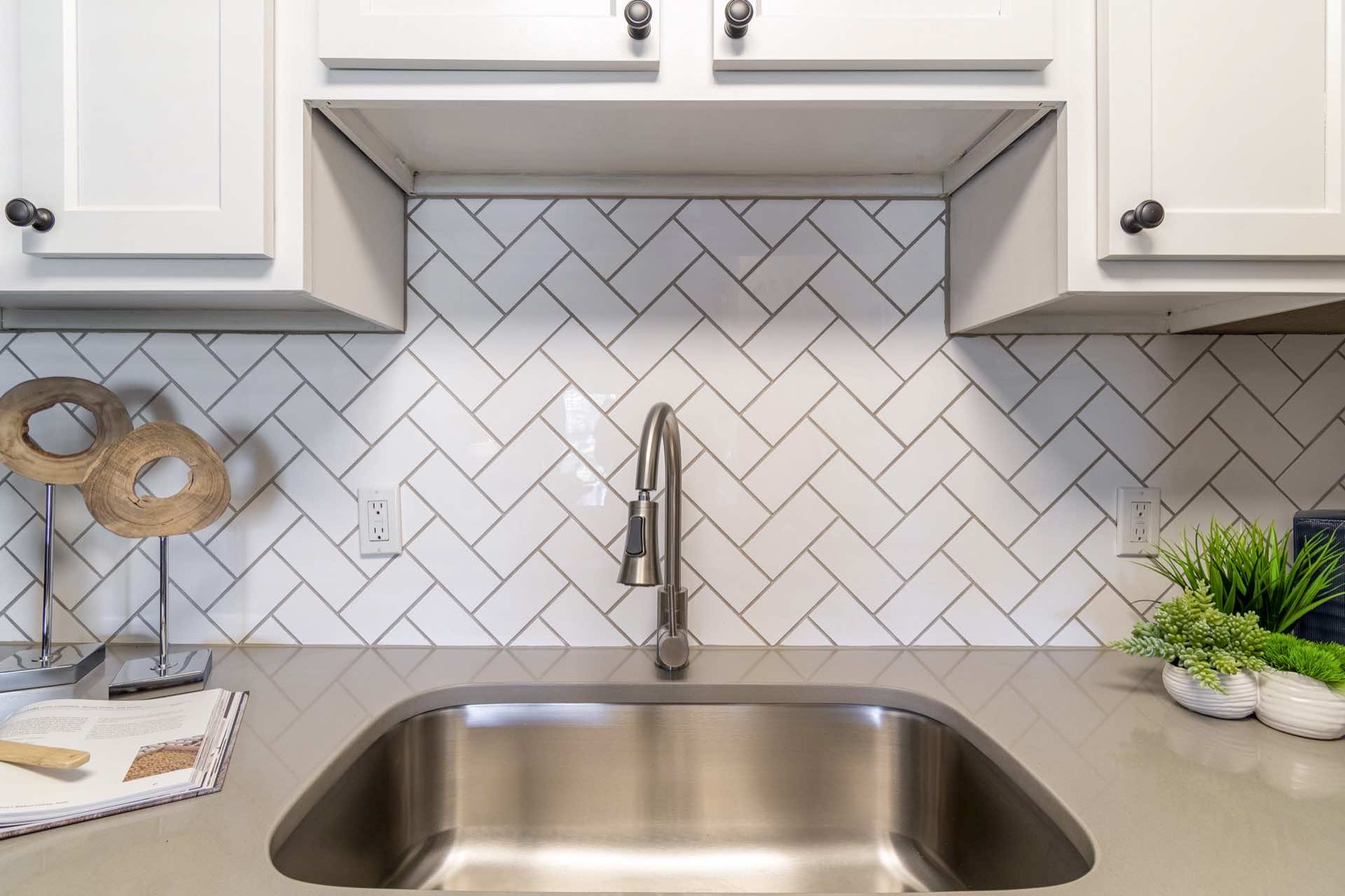kitchen with timeless white herringbone subway tile and gooseneck faucet